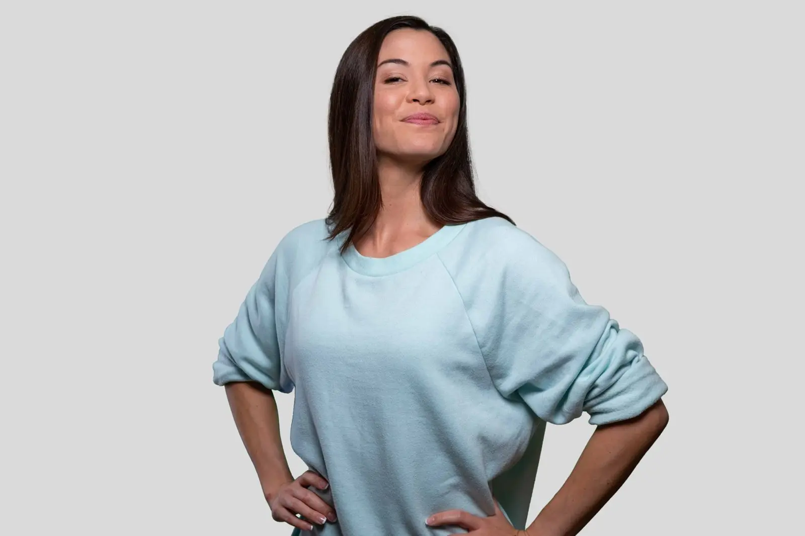 Woman standing with her hands on her hips, smiling