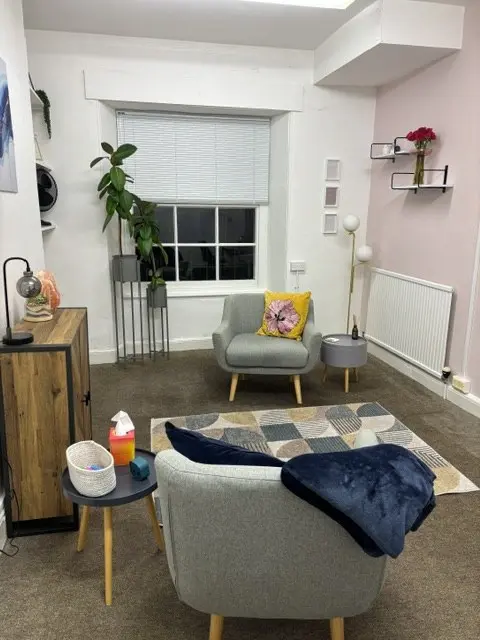 Alicia’s counselling room in Plymouth: soft grey armchairs, plants and warm light